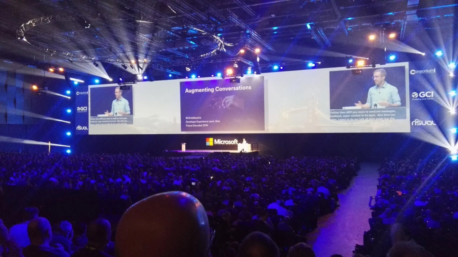 Chris Messina speaking at a Microsoft conference, projected on giant screens above a packed auditorium